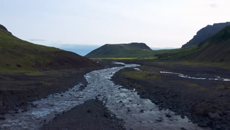 Seichtes-Wasser,-Das-In-Den-Felsigen-Fluss-In-Der-Nähe-Von-Seljavallalaug-Mit-Blick-Auf-Die-Berge-In-Island-Fließt