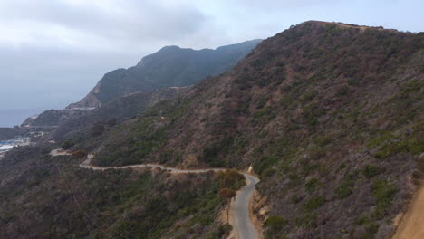 Drone-View-of-Winding-Wrigleys-Road-on-Catalina-Island-Hillside-on-Cloudy-Day,-tilt-down