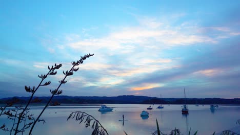 Ruhiger-Magischer-Sonnenuntergang-Am-Whakatane-See-Mit-Verankerten-Booten-Und-Stand-Up-Paddleboarding