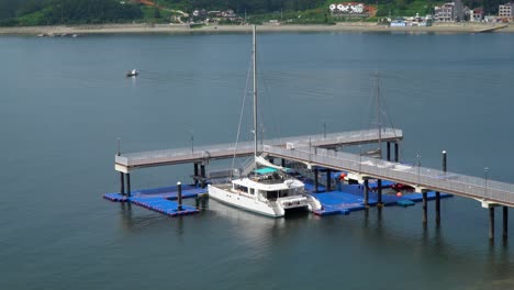 Catamaran-Boat-For-Tourists-Docked-At-Terminal-By-The-Calm-Sea-In-Summer