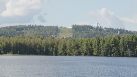 Bosque-Cortado-Por-Pista-De-Esquí-Lejos-Y-Paisaje-Lacustre-En-Jyväskylä,-Finlandia