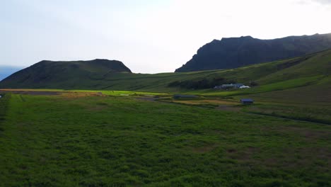 Paisaje-De-Hierba-Con-Montañas-Al-Fondo-Cerca-De-La-Piscina-Seljavallalaug,-Sur-De-Islandia