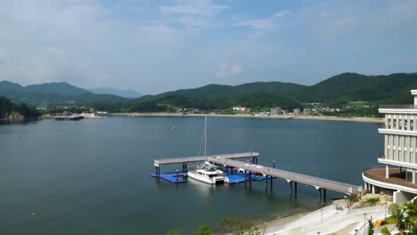 Ferry-Boat-On-Dock-In-Front-Of-Belvedere-Hotel-In-Geonje-South-Korea---wide-shot