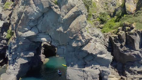 Aerial-at-Whale-Island-in-New-Zealand-with-kayakers-in-open-shore-cave