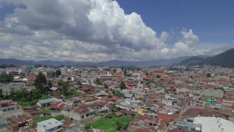 Drone-aerial-footage-of-central-american-urban-colonial-city-of-Quetzaltenango,-Xela,-Guatemala-showing-beautiful-cityscape-with-colorful-rooftops