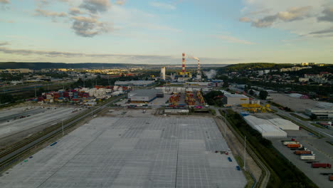 Aerial-View-Of-Warehouse-And-Container-Terminal-In-Gdynia,-Poland-With-Industrial-Plant-In-Background