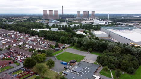 British-industrial-residential-neighbourhood-aerial-view-across-power-station-suburban-houses-and-streets-panning-left
