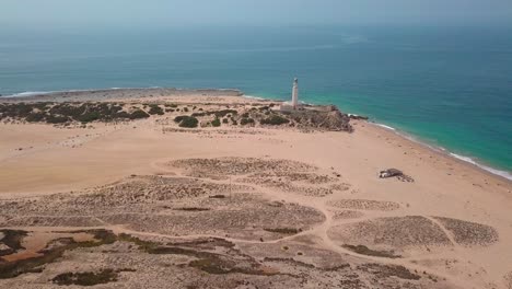 Playa-De-Cabo-Trafalgar-Y-Faro-Con-Aguas-Tranquilas-Del-Paisaje-Marino-Durante-El-Verano-En-Cádiz,-España
