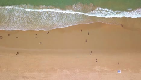 Touristen,-Die-Im-Sommer-Am-Sandstrand-Mit-Meereswellen-In-Kap-Trafalgar,-Cadiz,-Spanien,-Spazieren-Gehen