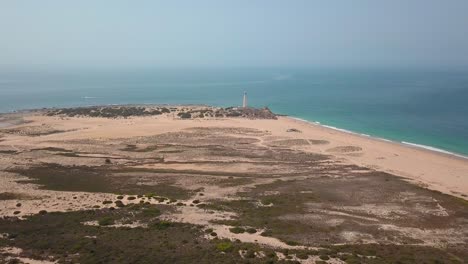 Distant-View-Of-Cape-Trafalgar-Lighthouse-Built-On-Historic-Headland-At-The-Atlantic-Ocean-Coast-In-Cadiz,-Spain