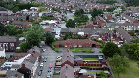 Aerial-view-orbit-right-above-British-neighbourhood-small-town-residential-suburban-property-gardens-and-town-streets