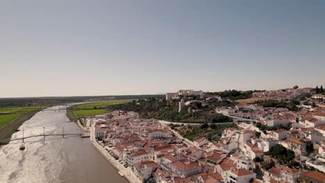 Aerial-ascending-shot-capturing-riverside-townscape-along-sado-river-with-clear-sky