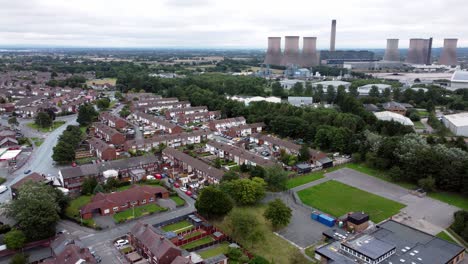 British-industrial-residential-neighbourhood-aerial-view-across-power-station-suburban-houses-and-streets-slow-left-pan