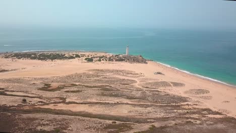 Scenic-View-Of-Beach-With-Cape-Trafalgar-Lighthouse-On-A-Sunny-Summer-Day-In-Cadiz,-Spain