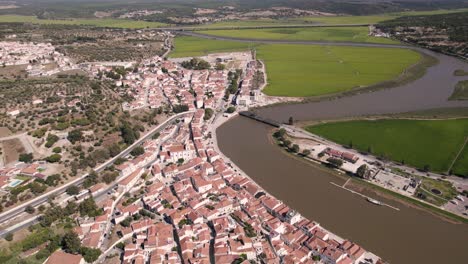 Birds-eye-view-of-riverside-parish-townscape-and-rice-paddy-fields-alongside-sado-river-channel
