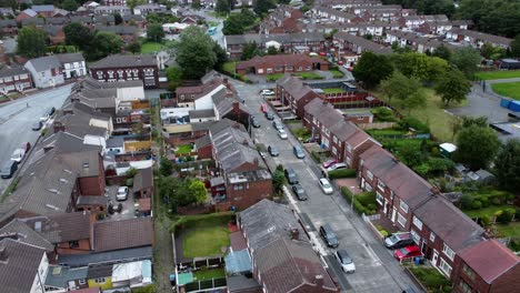 Aerial-view-above-British-neighbourhood-small-town-residential-suburban-property-gardens-and-town-streets-lowering