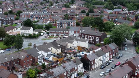Aerial-view-above-British-neighbourhood-small-town-residential-suburban-property-gardens-and-town-streets-left-dolly