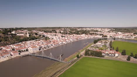 River-Sado-and-cityscape-of-beautiful-town-Alcacer-Do-Sal-in-Portugal,-aerial-view