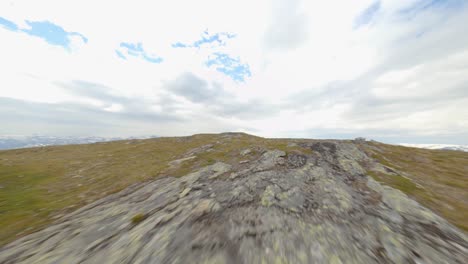 Aerial-fpv-flight-over-mountaintop-of-Rossnos-Mountain-with-epic-view-during-cloudy-day---Trekking-t-signs-on-rocks,-waymark-for-hike