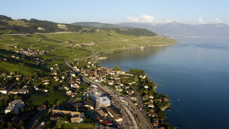 Aerial-View-Of-Vineyards,-Cully-Village,-And-Railroad-On-Lakefront-Of-Lake-Geneva-In-Lavaux,-Switzerland