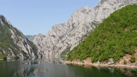 Beautiful-alpine-mountains-reflecting-on-calm-water-of-lake-in-Northern-Albania