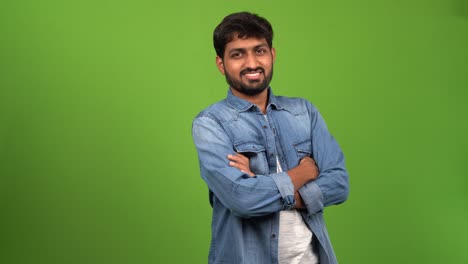 Handsome-Asia-Male-standing-with-folded-hands-for-a-photo-shoot-in-front-of-green-screen