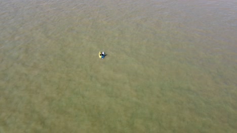 Aerial-View-Of-Two-Paddle-Boarders-Floating-Past-On-North-Sea