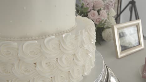 Close-up-of-the-base-of-the-wedding-cake-in-a-detail-of-roses