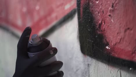 Slow-motion-shot-of-hand-painting-graffiti-on-wall,close-up---crime-at-night-in-Buenos-Aires