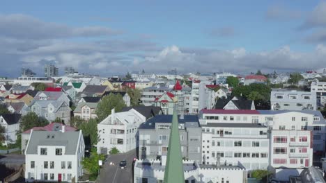 Lowering-in-front-of-house-of-prayer,-Lutheran-Church-with-cross-on-bell-tower,-Reykjavik
