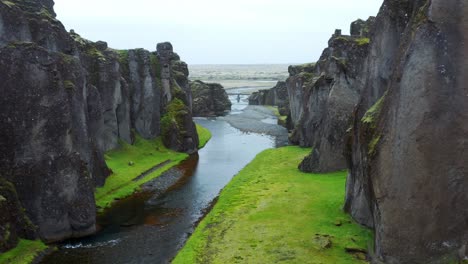 River-Flowing-Through-Beautiful-Fjaðrárgljúfur-Canyon,-Near-Kirkjubaejarklaustur,-Iceland---aerial-drone-shot