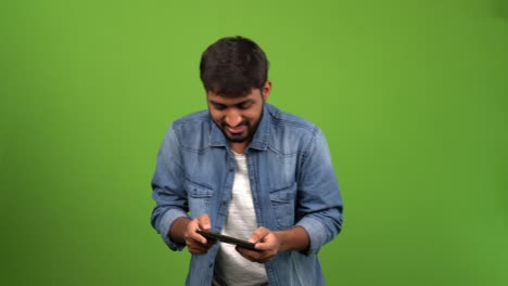 Young-attractive-Asian-man-playing-games-on-a-mobile-phone-and-enjoying