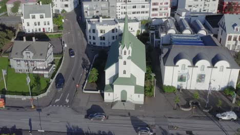 Free-Lutheran-Church-in-Reykjavik,-sunlight-during-dusk,-Iceland,-aerial