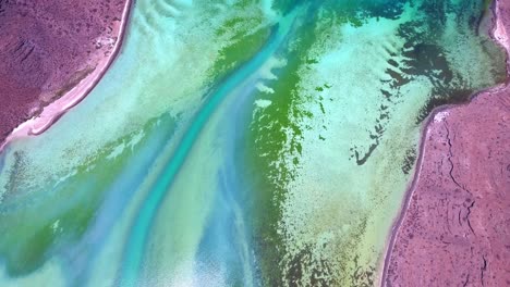 Overhead-Aerial-of-Underwater-Shifting-Sandbeds-with-Unique-Algae-Formations-near-Red-Volcanic-Land-Edge