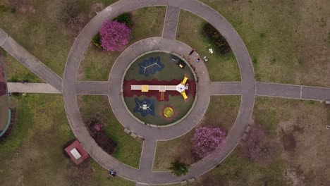 Aerial-top-down-view-of-a-circular-playground-for-children-inside-a-park