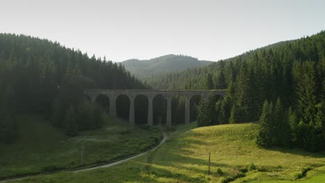 Vista-Aérea-De-Un-Tren-De-Pasajeros-Que-Cruza-El-Viaducto-De-Chmarocsky-En-Eslovaquia