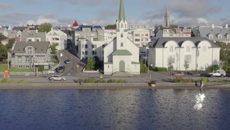 Flying-away-from-picturesque-Free-Church-in-center-of-Reykjavik,-Iceland