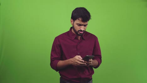 Handsome-man-reading-smartphone-text-with-disappointment,-isolated-on-green-screen
