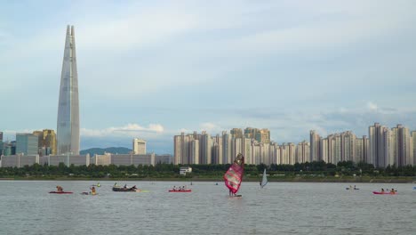 People-Enjoying-Water-Activities-At-Han-River-With-A-View-Of-Seoul-Skyline-And-Lotte-World-Tower-Skyscraper-In-South-Korea