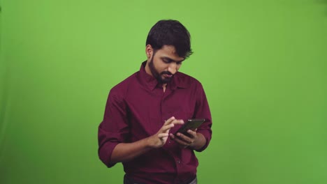 Handsome-man-scrolling-through-social-media,-isolated-on-green-screen