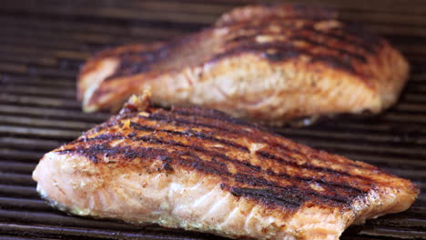 Seasoned-and-grilled-salmon-steaks-on-the-barbecue-done-and-ready-to-serve---slow-zoom-close-up-isolated-view