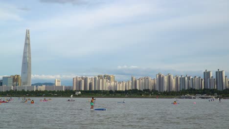 Tourist-On-Water-Recreational-Sports-At-River-Han-With-Lotte-World-Tower-Backdrop-In-Seoul,-South-Korea