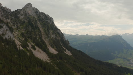 Speedramping-Drohne-über-Einen-Bergrücken-Geschossen,-Der-Mit-Dem-Blick-Auf-Die-Bergspitze-In-Der-Schweiz-Endet