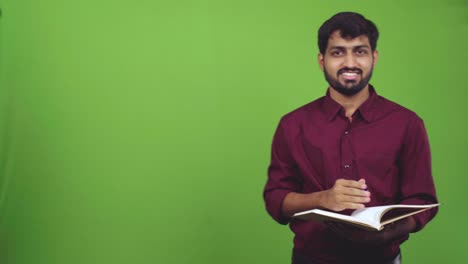 Attractive-male-teacher-explaining-lesson-and-pointing-to-blackboard,-isolated-on-green-screen