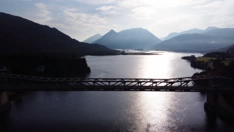 Cars-Driving-over-Ballachulish-Bridge-at-Loch-Leven-near-Glencoe-on-the-West-Coast-of-Scotland-with-Morning-Sun,-Aerial-Drone-4K-HD-Footage-Fly-Out