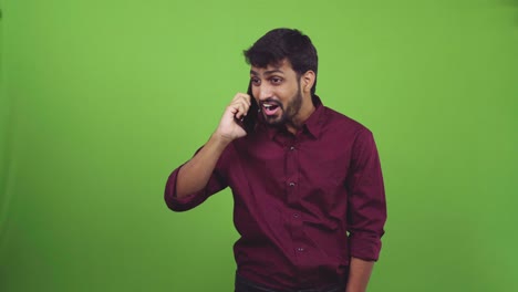 Handsome-man-taking-a-call-and-talking-with-surprise,-isolated-on-green-screen