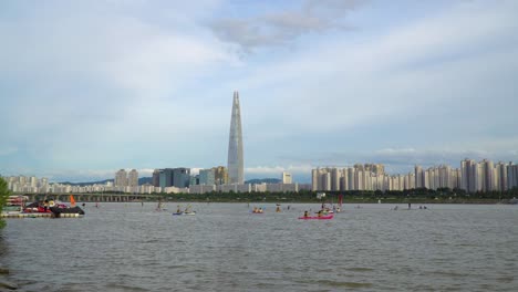 Wassersportaktivitäten-Am-Han-Fluss-Mit-Wolkenkratzer-Lotte-World-Tower-Im-Hintergrund-In-Seoul,-Südkorea