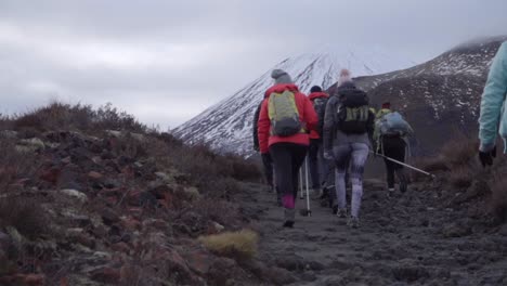 Hikers-going-up-Mount-Tongariro-in-winter-time-on-cloudy-day,-group-excursion
