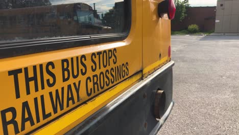 THIS-BUS-STOPS-AT-RAILWAY-CROSSINGS-caution-warning-on-back-of-school-bus