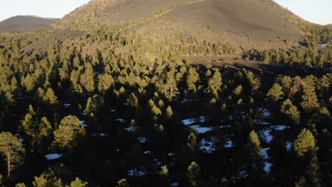 Drone-flying-over-Sunset-Crater-volcano-at-national-monument,-Arizona-showing-Cinder-cone-volcanic-mountain